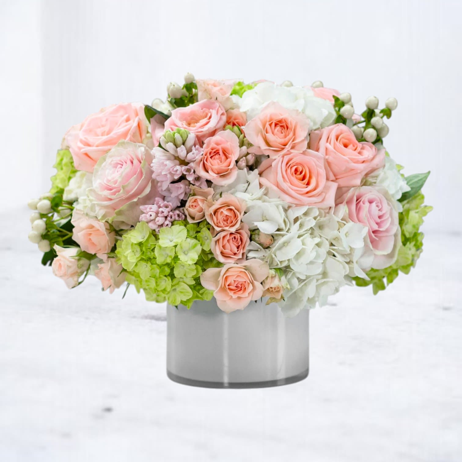 Pink and white rose arrangement in a gray vase