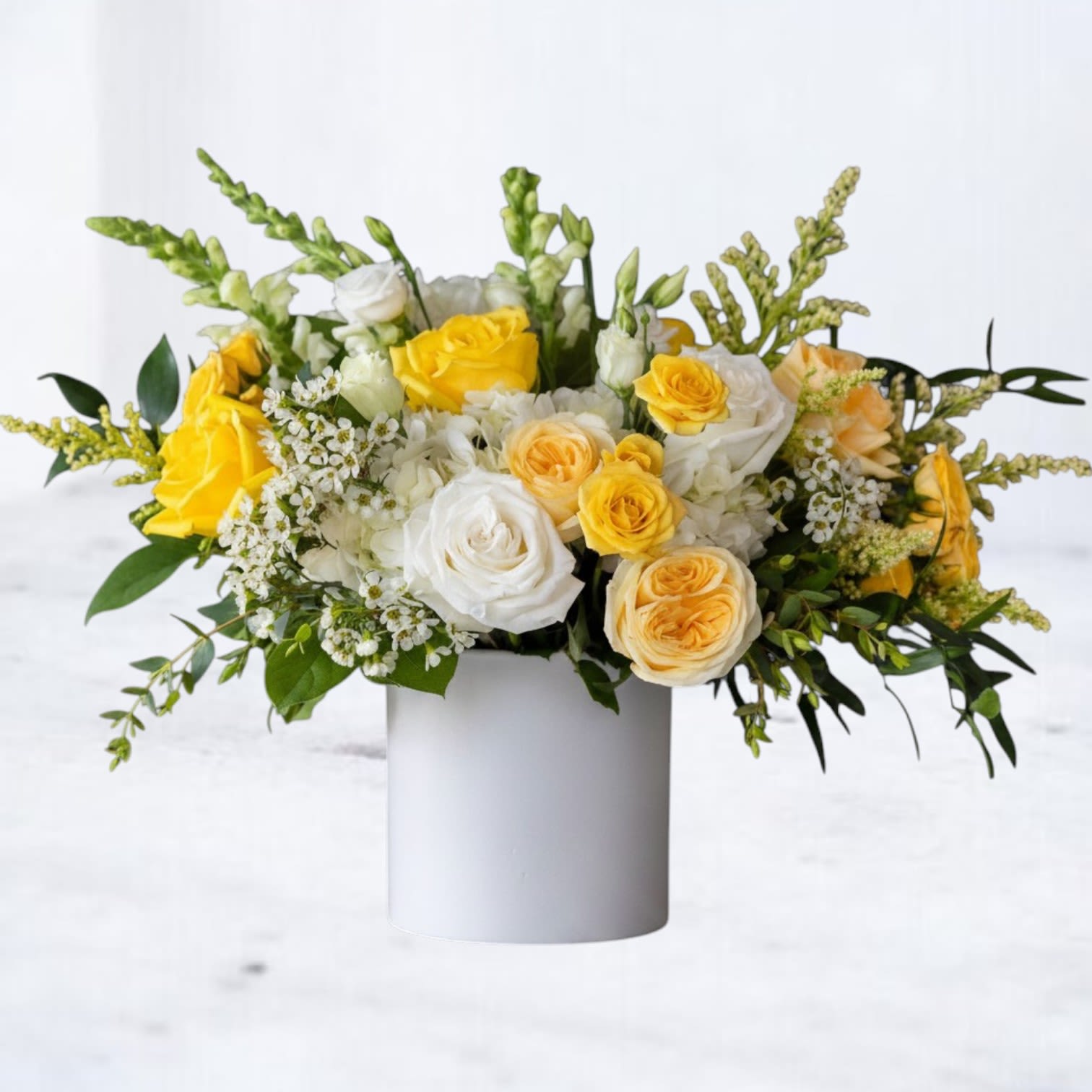 Citrine &amp; Silk - Citrine &amp; Silk is a bright, garden-style floral arrangement designed with soft texture, natural movement, and a fresh, uplifting palette. Featuring vibrant yellow roses, creamy white roses, soft spray roses, and delicate seasonal blooms, this arrangement is layered with fresh greenery to create a full, airy composition.  Designed in a modern ceramic vessel, Citrine &amp; Silk blends radiant yellows with soft ivory tones and lush greens for a look that feels light, elegant, and effortlessly cheerful. The balance of structured roses and airy accents gives this design a refined, natural presence with a clean, modern finish.  Perfect for birthdays, get well wishes, thank-you gifts, sympathy flowers, or simply brightening someone’s day, this yellow and white flower arrangement offers a timeless, uplifting style for any occasion.  Same-day flower delivery is available in Magnolia, TX, The Woodlands, Montgomery, Conroe, Spring, Tomball, and surrounding North Houston areas.  Due to seasonal availability, some blooms may be replaced with similar varieties of equal or greater value to maintain the design’s look and integrity. Your arrangement will always reflect the same color palette, style, and premium quality.