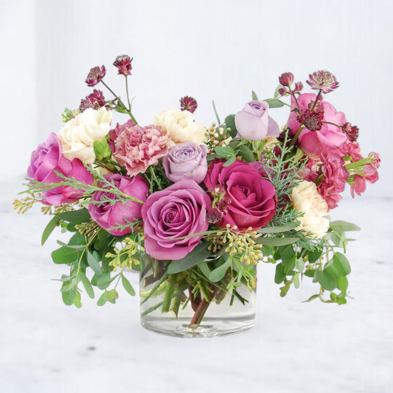 Wild Madrigal - Unleash the beauty of bold expression with our Wild Madrigal arrangement — a lush, artfully designed bouquet that sings with movement and color. This floral composition blends rich berry-toned roses, soft lavender blooms, and wild-inspired textures with a symphony of greenery for a look that's effortlessly romantic and slightly untamed. Perfect for sending love, admiration, or creative celebration, this arrangement brings a touch of whimsy and elegance to any space. Ideal for birthdays, just-because moments, or anyone with a free spirit and a love for artistic flair.