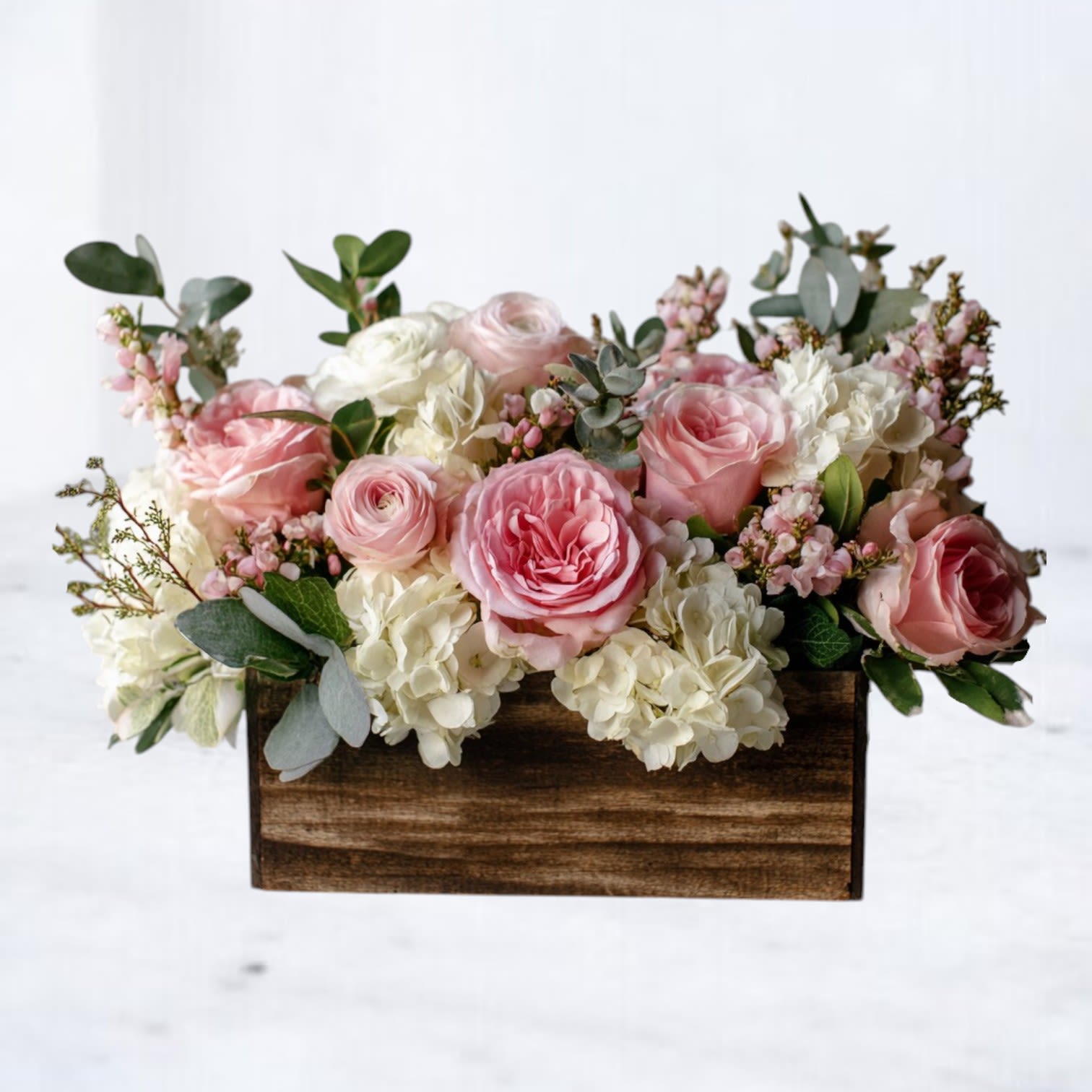Blushwood - Blushwood features soft pink roses, creamy hydrangea, and delicate seasonal accents arranged with fresh greenery in a rustic wooden box. The blend of warm blush tones and natural textures creates a full, balanced design that feels both relaxed and thoughtfully styled.  Perfect for birthdays, thank-you gifts, or sending something beautiful that feels easy and well put together.  Available for same-day flower delivery in Magnolia, Montgomery, The Woodlands, Conroe, and surrounding areas. Flower varieties may vary slightly while maintaining the overall look and color palette.