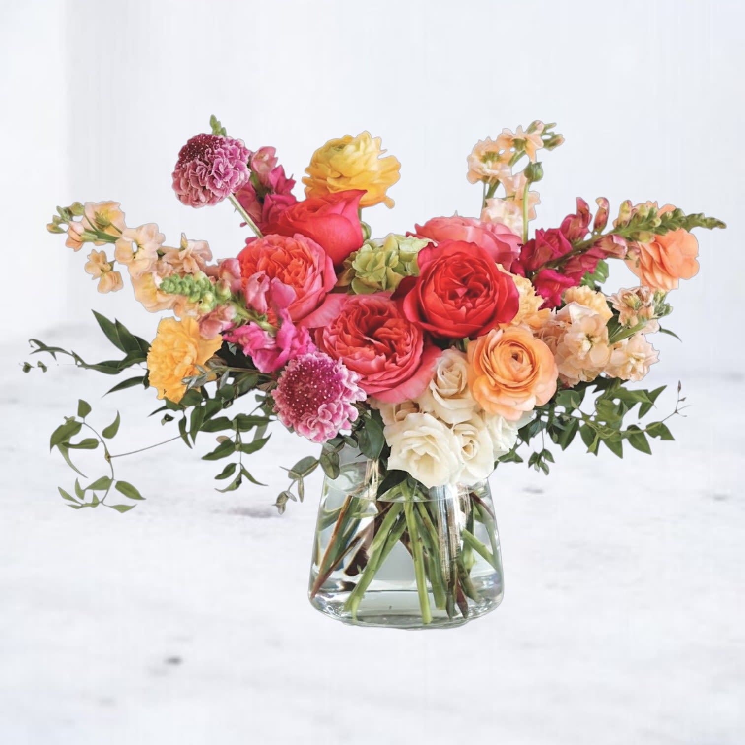 Bright Mix - Bright Mix is a vibrant, garden-inspired floral arrangement designed with bold color, natural movement, and a fresh, modern feel. Featuring coral and peach roses, golden yellow blooms, soft ivory accents, and seasonal florals, this arrangement is layered with fresh greenery to create a lively, textured composition.  Designed in a clear glass vase, Bright Mix blends warm tones and dynamic color transitions for a look that feels cheerful, elevated, and full of life. The mix of bright hues and soft neutrals creates a balanced design that stands out while still feeling refined and intentional.  Perfect for birthdays, celebrations, congratulations, thank-you gifts, or just because, this colorful flower arrangement delivers an uplifting, feel-good design that brings energy and warmth to any space.  Same-day flower delivery is available in Magnolia, TX, The Woodlands, Montgomery, Conroe, Spring, Tomball, and surrounding North Houston areas.  Due to seasonal availability, some blooms may be replaced with similar varieties of equal or greater value to maintain the design’s look and integrity. Your arrangement will always reflect the same color palette, style, and premium quality.