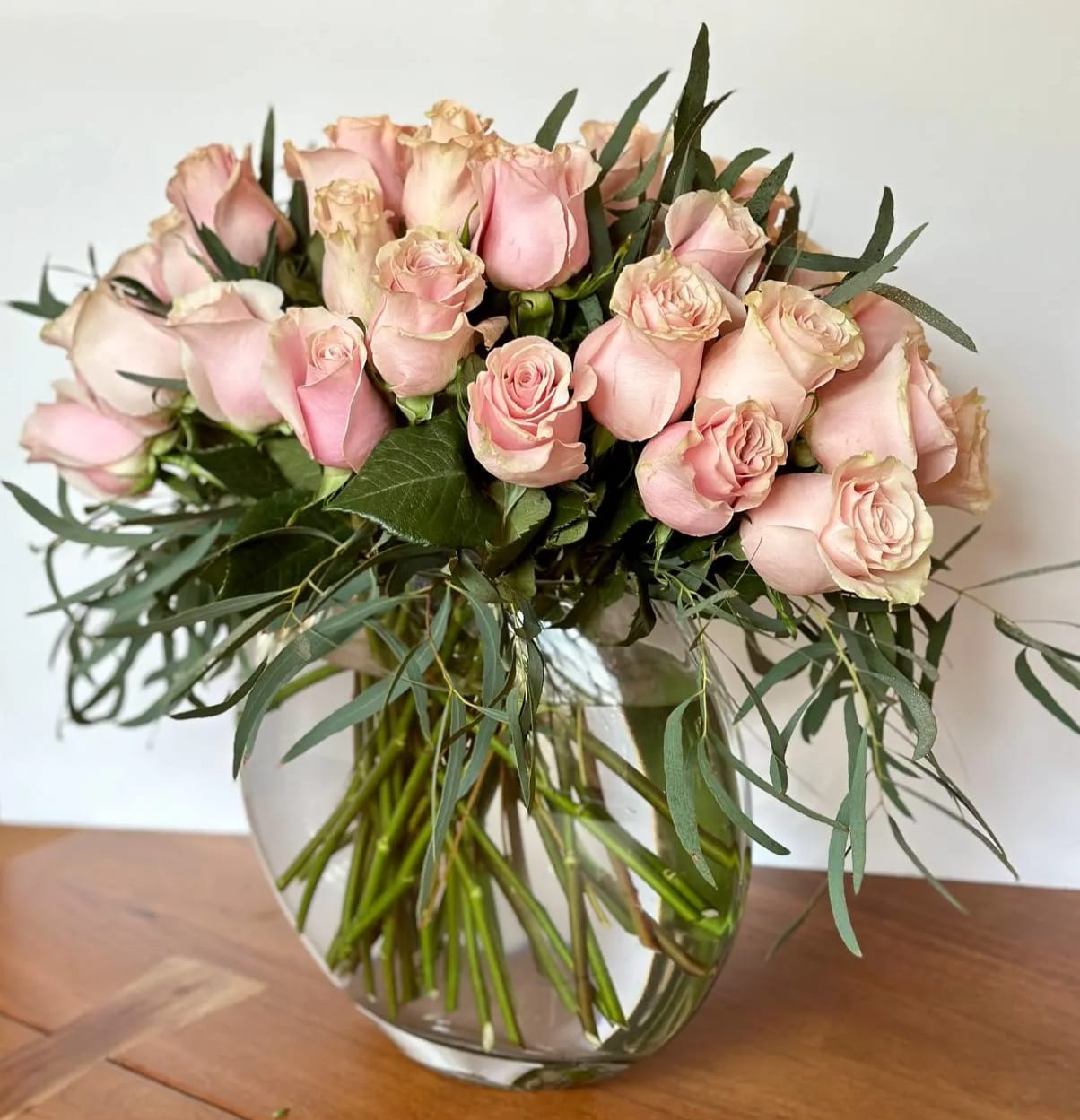 Bouquet of pale pink roses in a clear glass vase