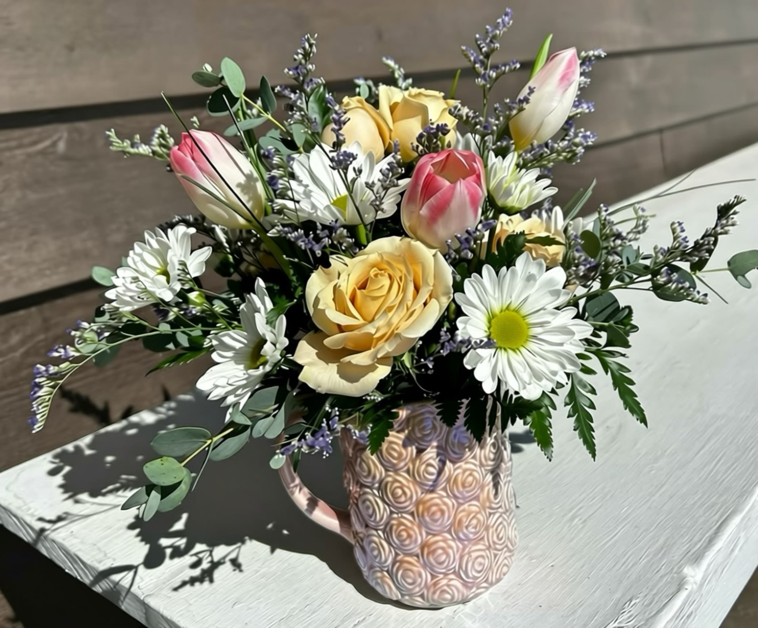 Cup of Cheer - This petite arrangement is perfect for any occasion or just to bring a smile to someone's face.  Designed in a pink cup with fresh blooms of the season the special recipient will have something to remember after the flowers are gone.