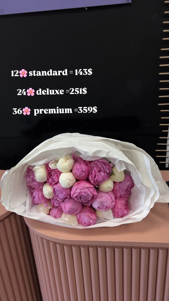 Bouquet of pink and white peonies wrapped in white paper