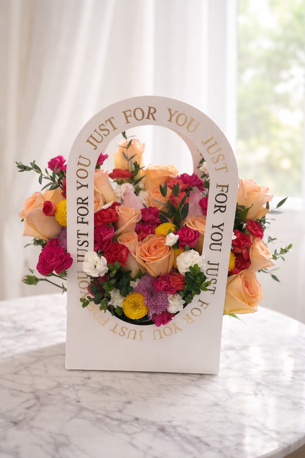 Mixed bouquet of peach roses, pink blooms, and yellow flowers in a white gift box