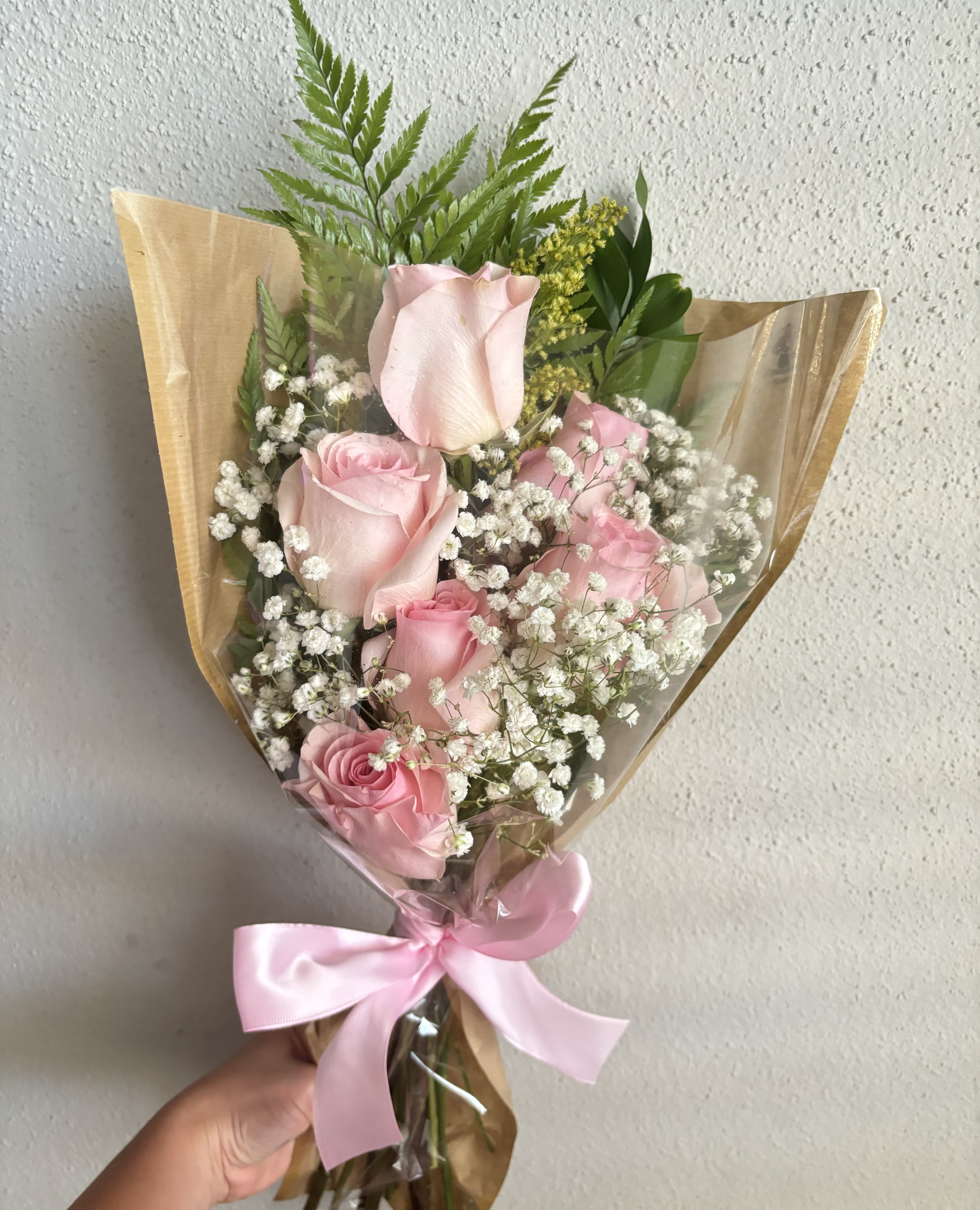 Bouquet of pink roses with baby's breath and a pink ribbon