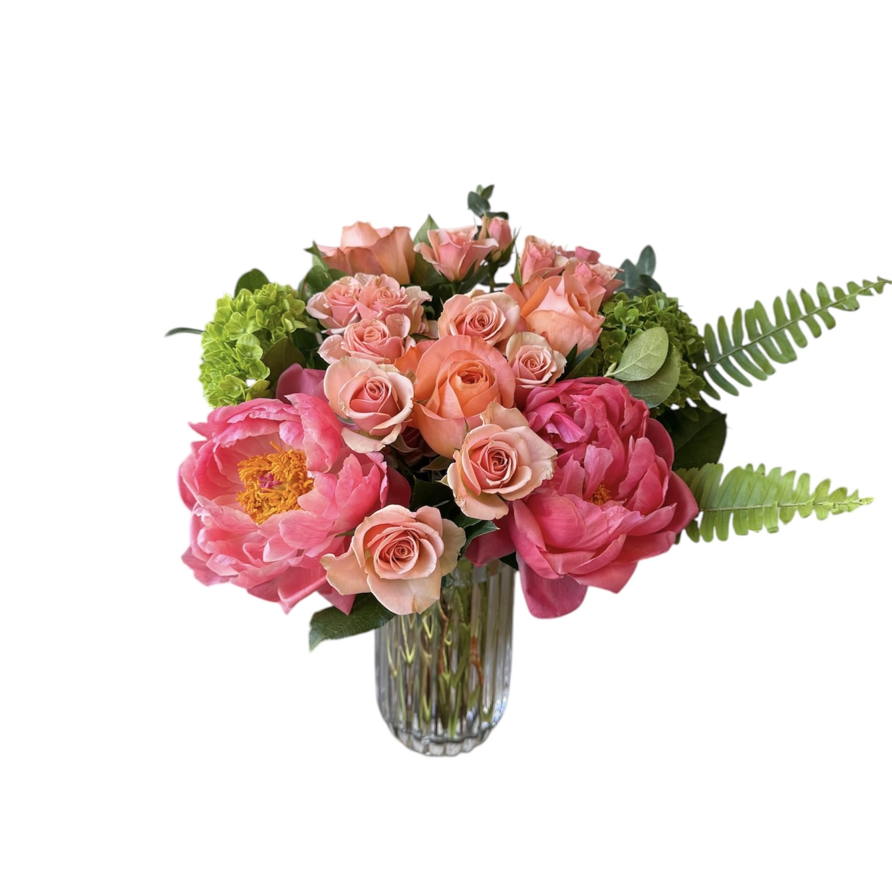 Mom's Favorite - Coral peonies, peach roses, peach spray roses, green hydrangea and fern designed in a tall crystal vase. As shown in photo. 