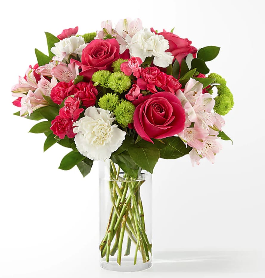 Pink roses, carnations, and alstroemeria in a clear glass vase