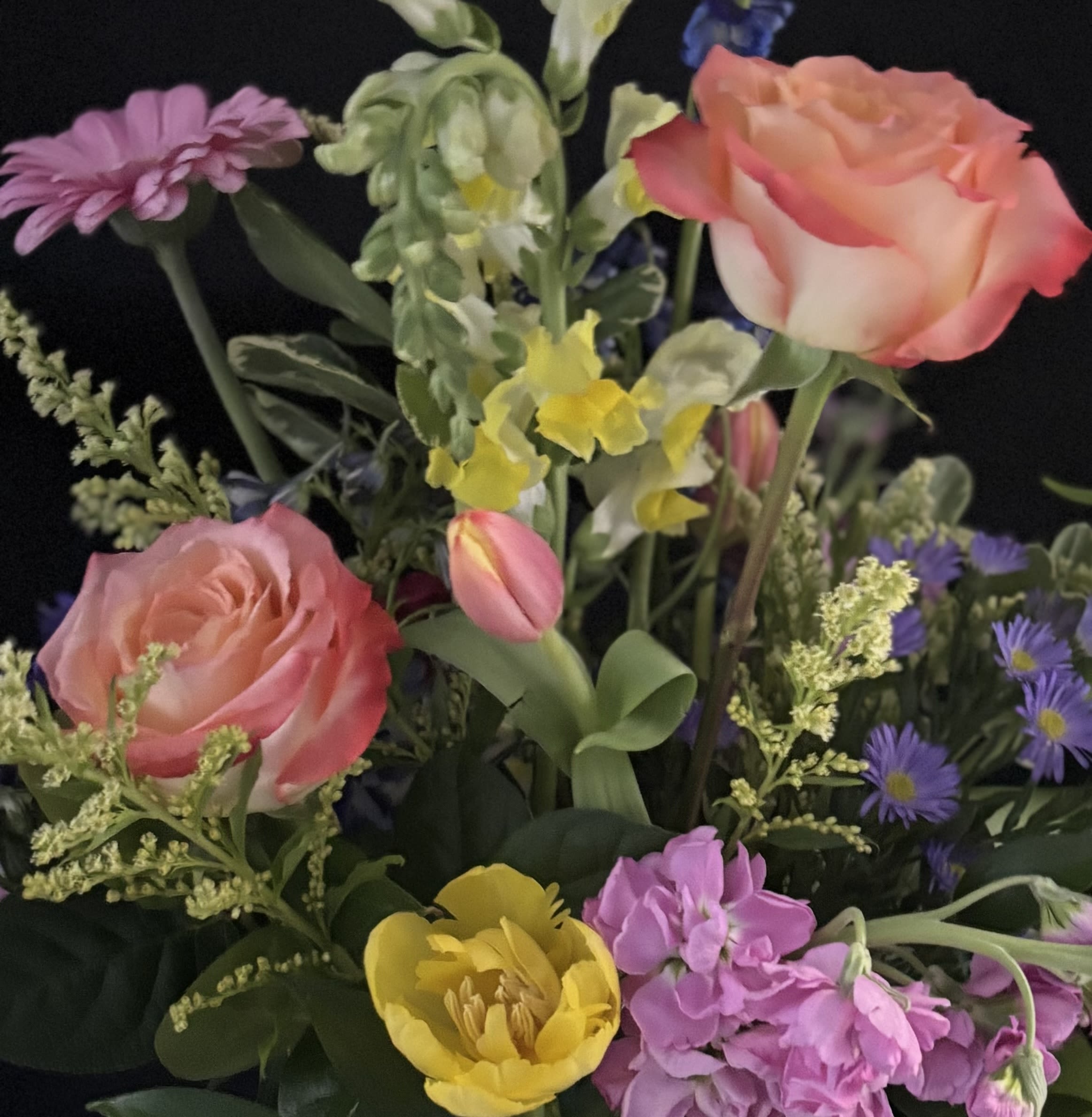 Tutti Frutti Wrapped Bouquet - If Mom loves color, this is the palette for her! Citrusy yellows and oranges, berry blues and pinks, and pops of grape! Tutti Fruitti Fun! Our team of designers will choose the freshest blooms and best colors available to create this bouquet.