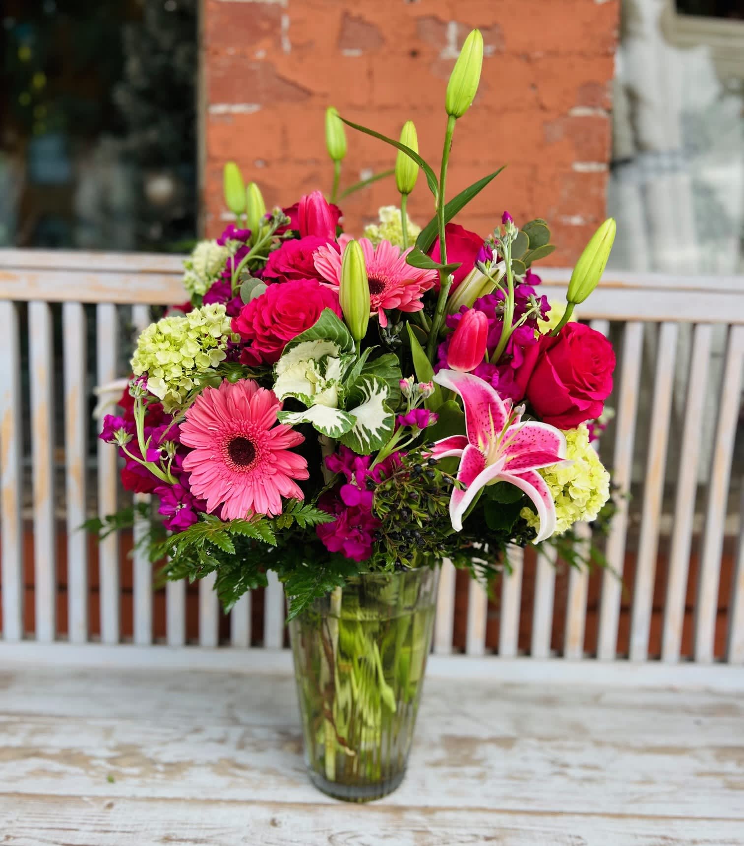 Mixed bouquet of pink and red flowers in a glass vase