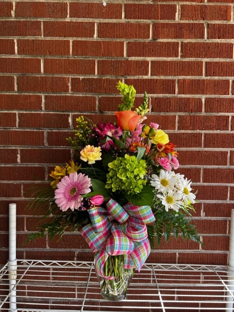 Mixed bouquet in a glass vase with a plaid bow