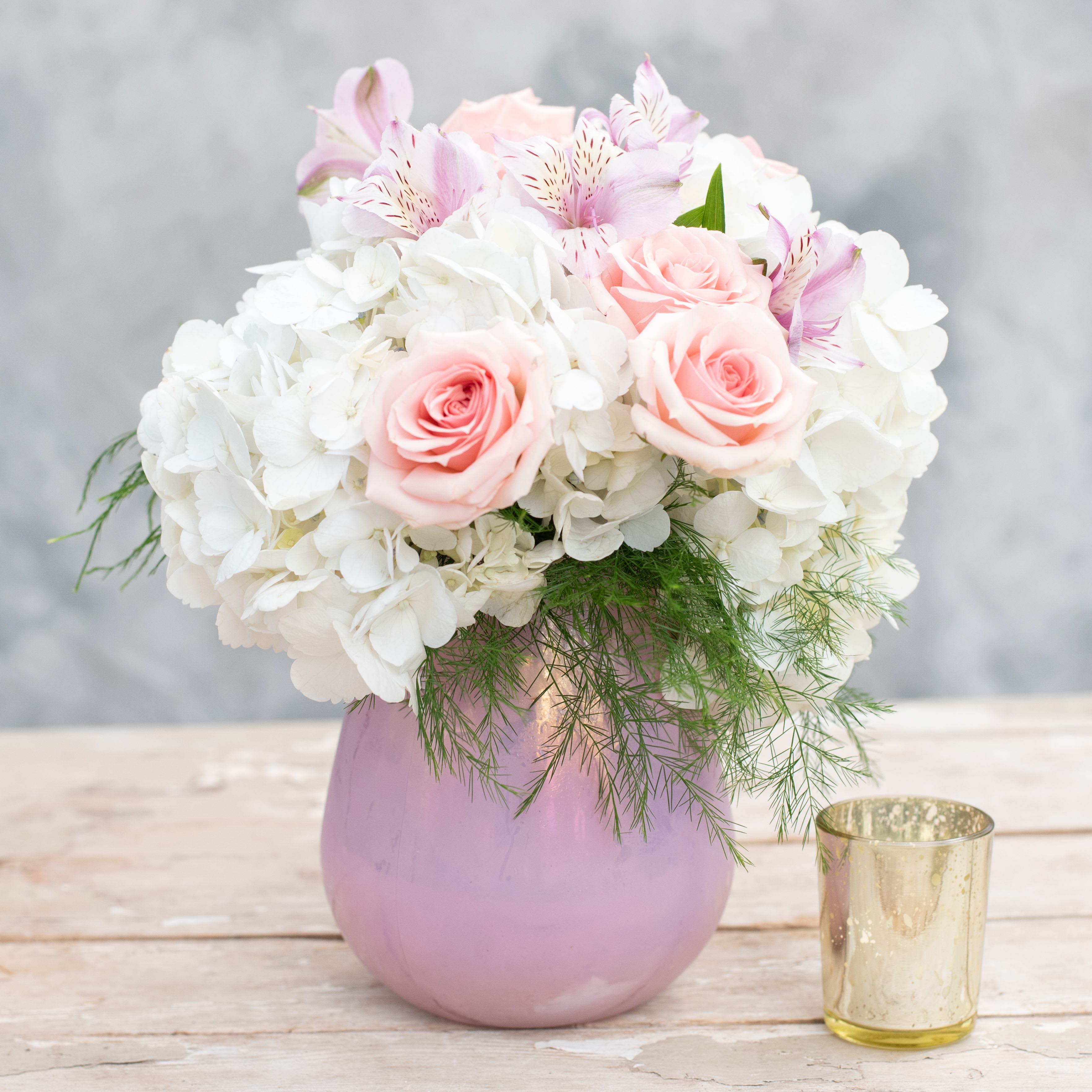 Mom's Favorite - Surely Mom will love this delicate, sweet, pink, white and lavender arrangement, including hydrangea, spray roses alstroemeria and premium greens.  The iridescent pink glass vase completes the look and will make this Mom's Favorite.