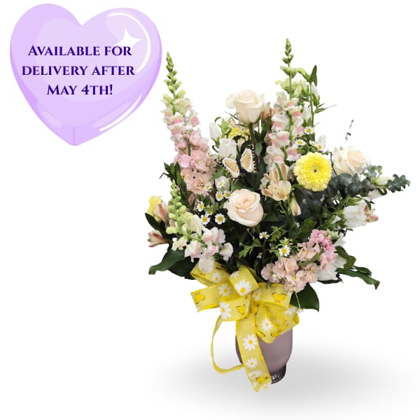  Antique Love - Pale cream roses and soft pink snapdragons give this tall, airy flower arrangement a vintage spring-morning feel-perfect as a Mother's Day, birthday, graduation, or "just because" gift. The design reads cheerful and feminine, promising the person you're thinking of will feel truly seen when these mixed-color blooms arrive.  This composition pairs yellow hermits daisies, pink snapdragons, alstroemeria, stock, Canterbury bells, chamomile, tulips, gerbera-style daisies and roses in a full, layered silhouette. Arranged with darker foliage in a ceramic vase and finished with a bright yellow ribbon, the bouquet stands approximately 29" x 19" x 16".  Ideal for brightening a bedside table, entryway, or celebration table during spring or any season, these long-stemmed flowers benefit from simple care: fresh water and a cool spot to keep blooms looking their best. Order when you want to mark a birthday, congratulate a grad, or send a sunny "thinking of you" moment.