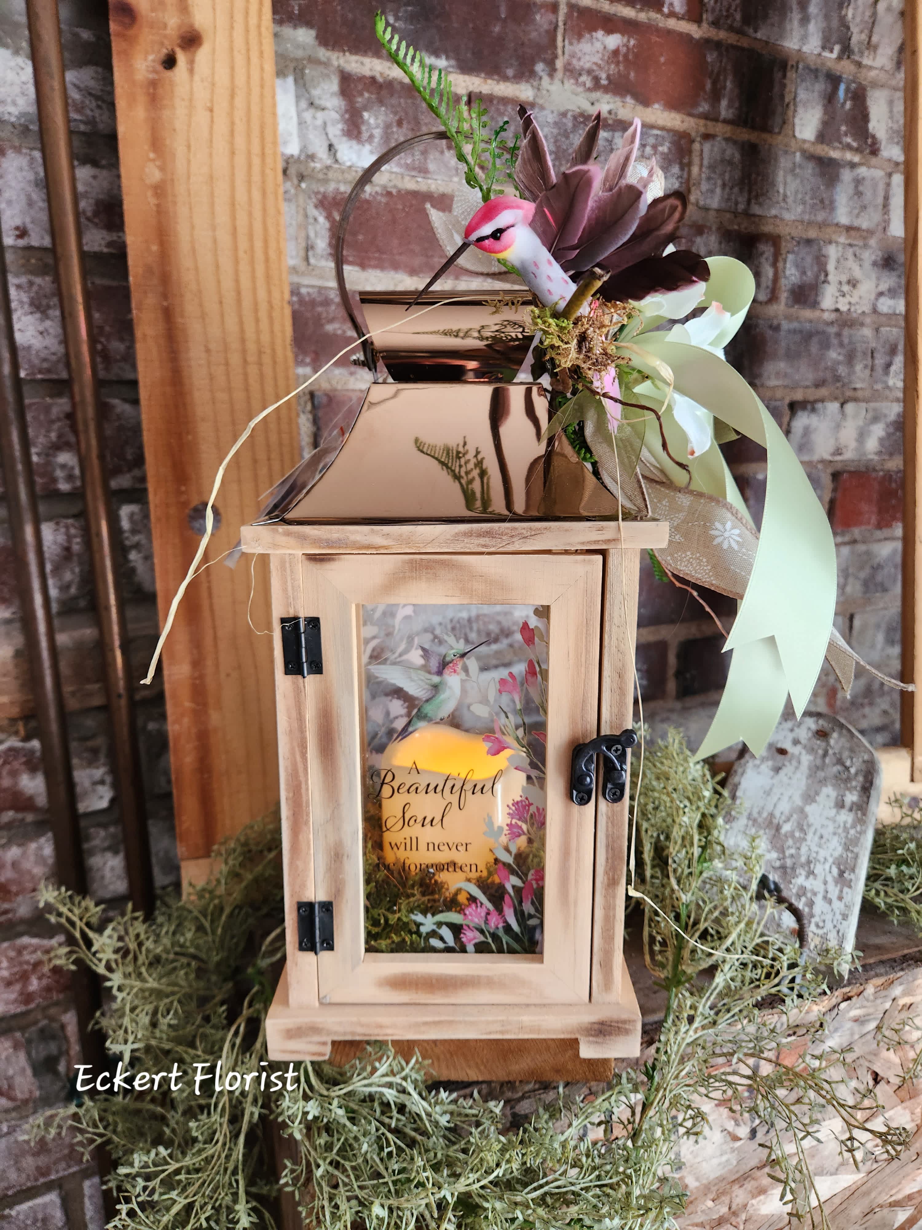  Eckert Florist's Copper Top Hummingbird Lantern *OUR LOCAL DELIVERY ONLY - Nice keepsake light wooden lantern with copper tin roof and sentiment on a floral and Hummingbird motif glass. Sentiment: "A Beautiful Soul will never be forgotten." Included is a battery operated candle. Measures approx. 6.25" Square x 15" High *OUR LOCAL DELIVERY ONLY