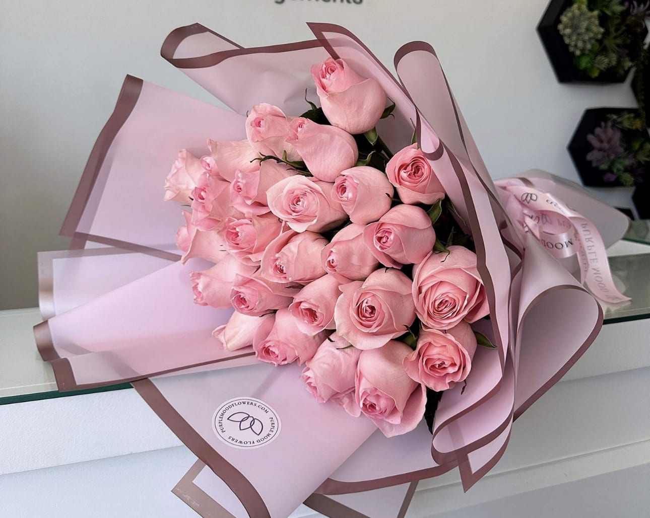 25 Long Stem Pink Roses Bouquet  - 25 long stem roses wrapped in paper. Soft, graceful, and full of charm, our 25 Long Stem Pink Roses bouquet is the perfect way to express admiration, gratitude, or gentle romance. Each delicate rose is hand-selected for its beauty and freshness, then wrapped in elegant pastel paper and tied with a satin ribbon. This bouquet radiates elegance and sweetness, making it a thoughtful gift for birthdays, anniversaries, congratulations, or simply to brighten someone’s day. Light pink or hot pink.      •    25 premium long stem pink roses     •    Wrapped in elegant pastel paper with satin ribbon     •    Symbolizes admiration, appreciation, and affection     •    Perfect for birthdays, anniversaries, celebrations, or “just because”  VASE NOT INCLUDED