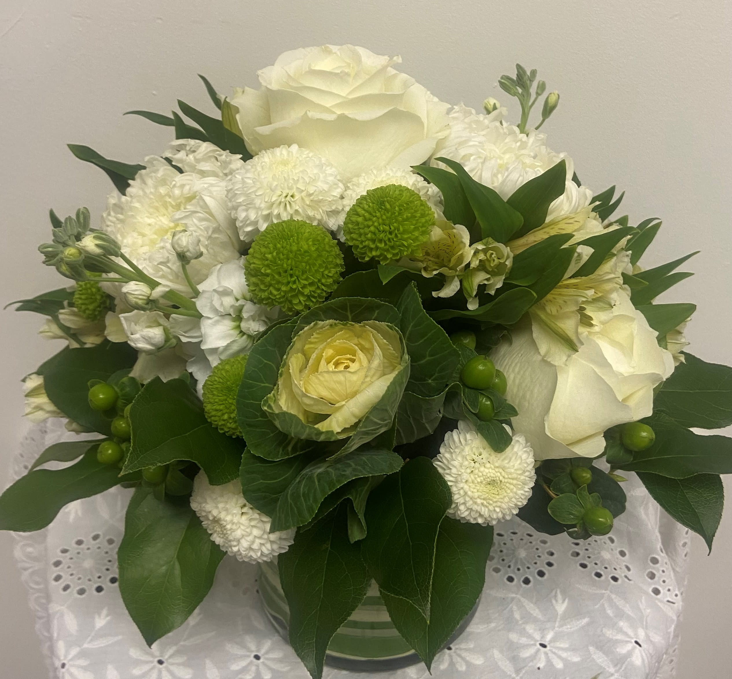White and green floral arrangement in a glass vase