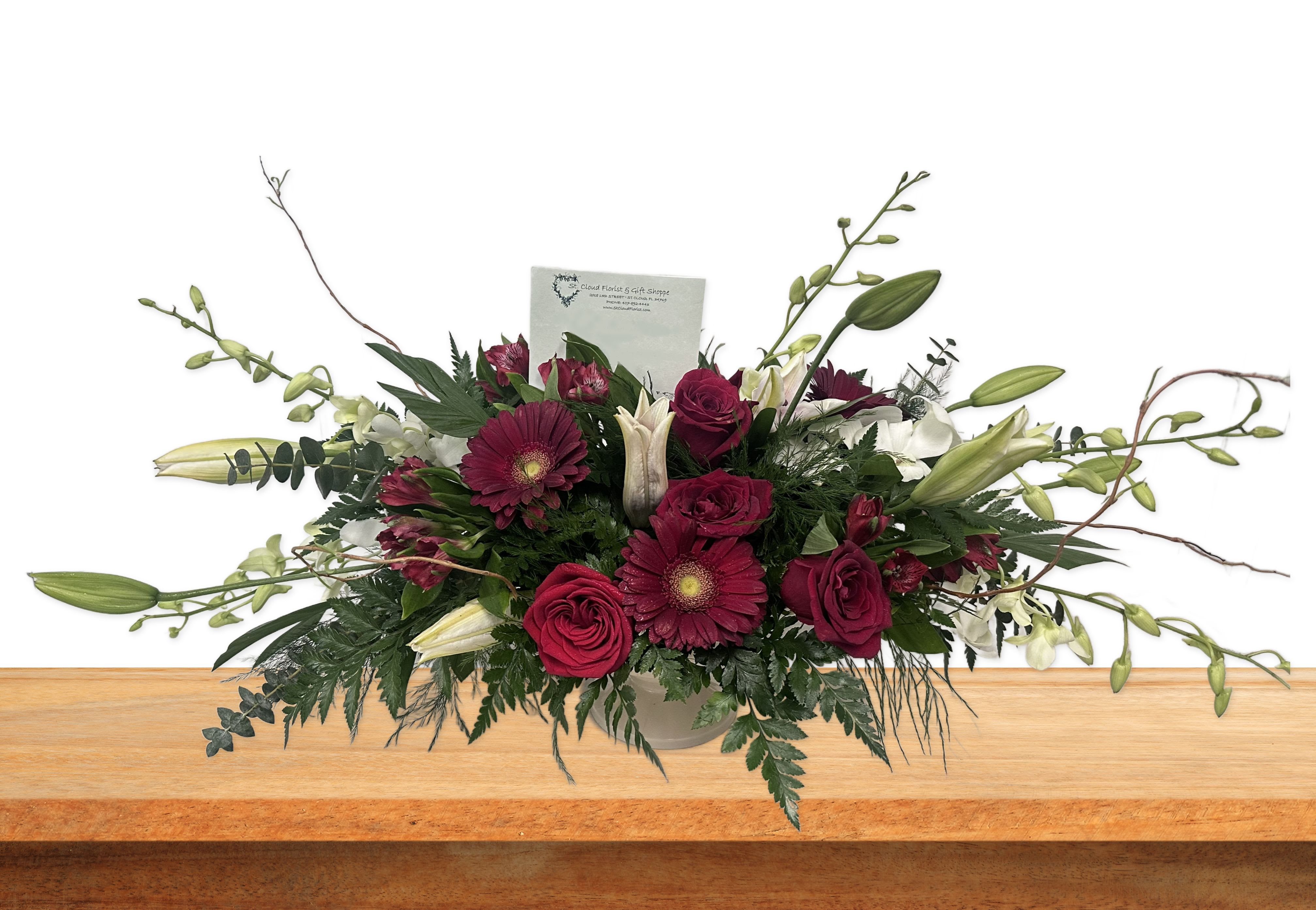Long floral arrangement with burgundy roses and lilies in a vase