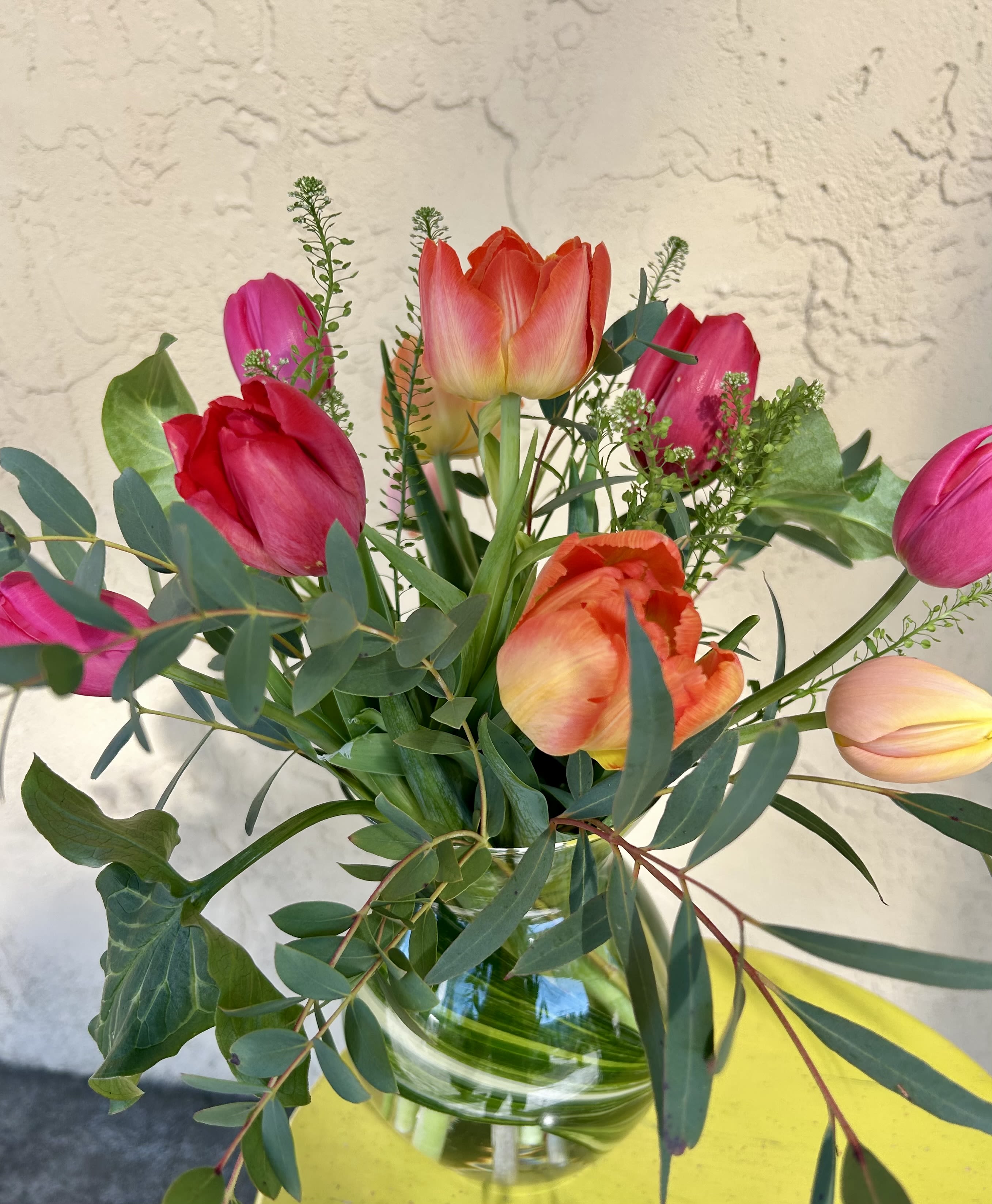 Bouquet of pink and orange tulips in a glass vase