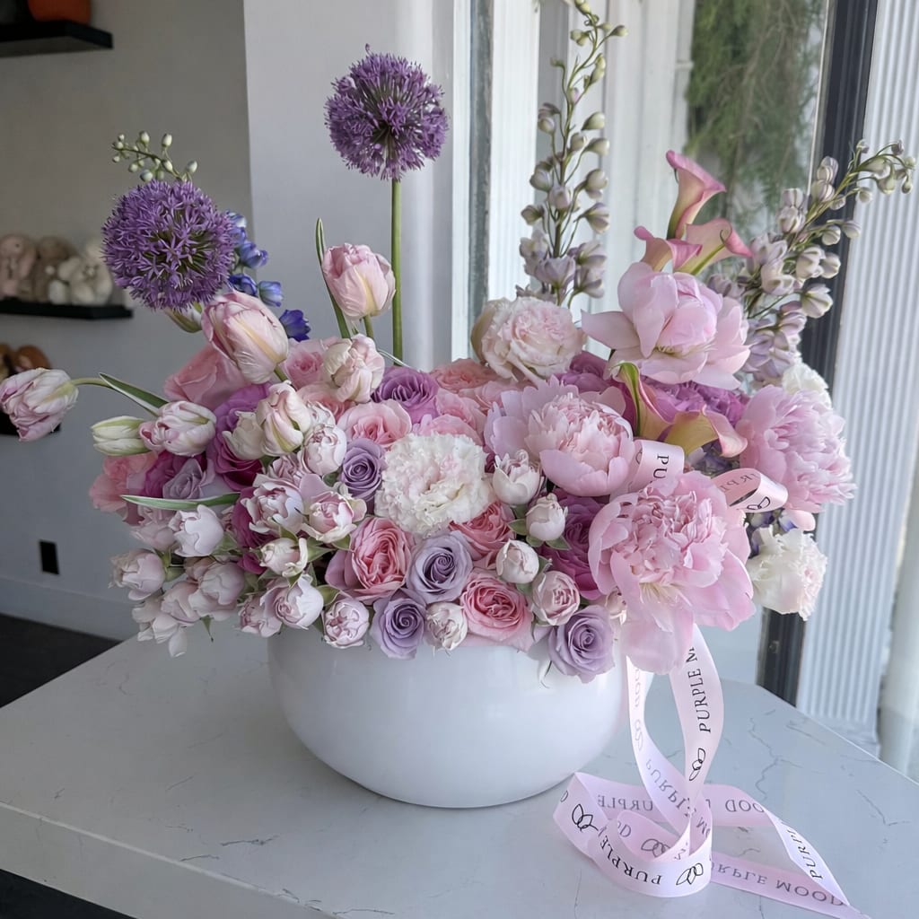 Beauty vase - Soft, romantic, and effortlessly elegant — this floral arrangement is designed in delicate shades of blush pink, lavender, and creamy white. Featuring lush peonies, garden roses, spray roses, tulips, and seasonal blooms, it creates a full, airy composition with gentle movement and texture.  Arranged in a modern, smooth white ceramic vase, this piece is perfect for Mother’s Day, birthdays, or adding a refined touch to any interior. Each design is handcrafted and may slightly vary based on flower availability, while maintaining the same overall look and color palette.  Same-day delivery available in Los Angeles.