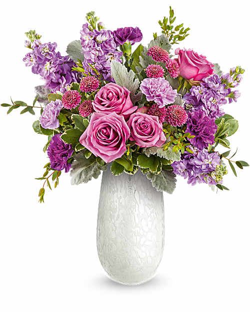 Amelia Bouquet - Delight Mom with the Amelia Bouquet, a graceful mix of pink and lavender blooms beautifully arranged in the Amelia Vase. This elegant art glass keepsake adds soft shimmer and a heartfelt touch to her Mother's Day.
