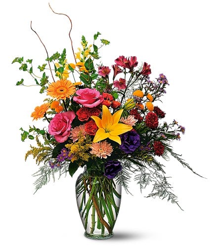 Mixed bouquet of colorful flowers in a clear glass vase