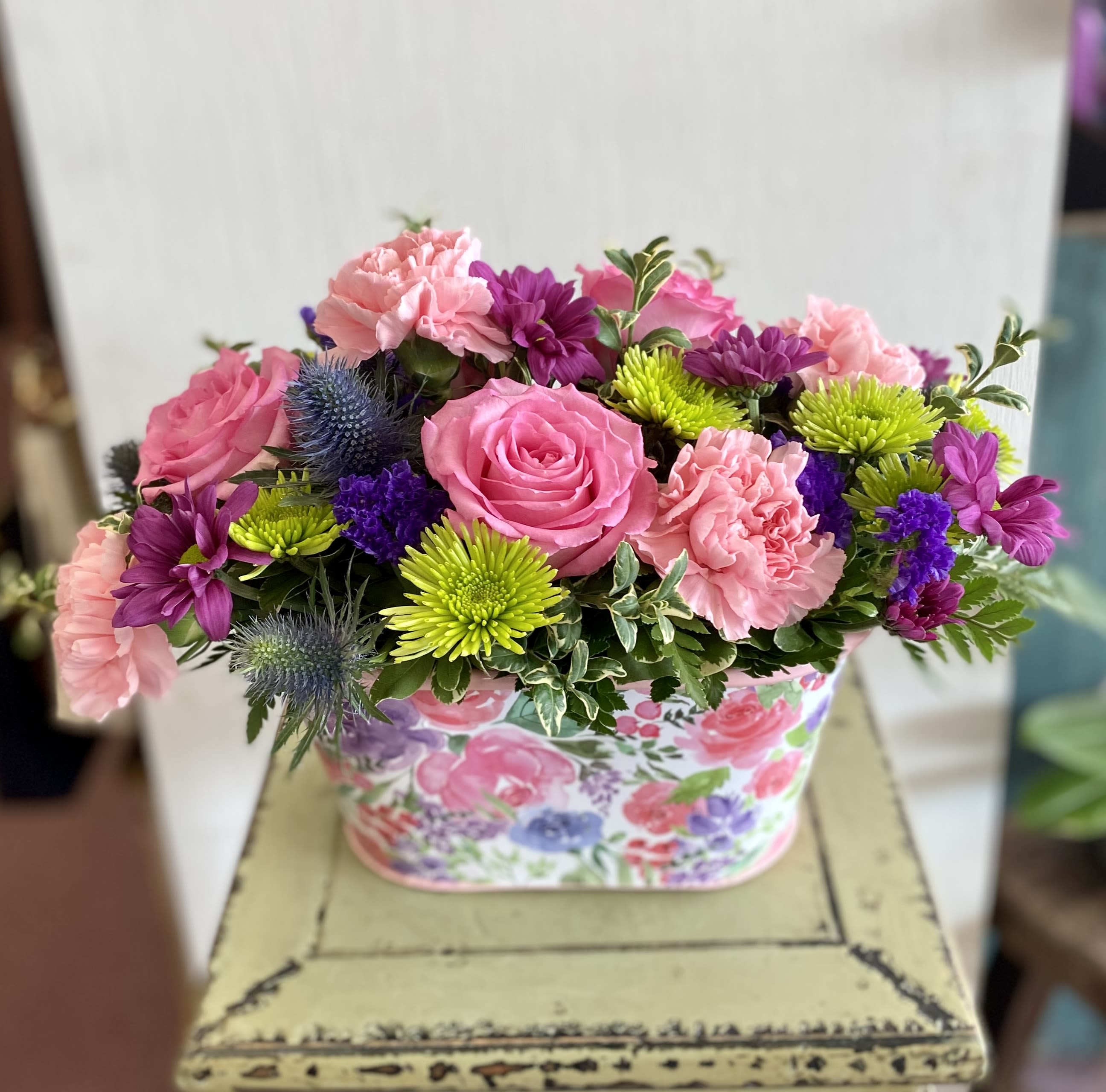 Pink and purple mixed flower arrangement in a floral box