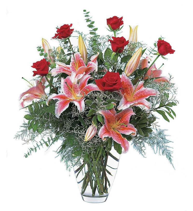 Red roses and pink lilies in a clear glass vase