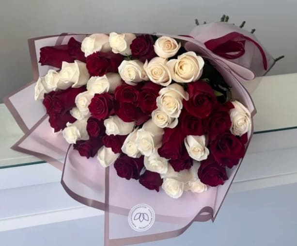 Red &amp; White Roses Bouquet  - 50 Roses.  Red &amp; White Roses Elegant and timeless, the Red &amp; White Roses arrangement is a stunning expression of love and harmony. The striking contrast of deep red and pure white creates a bold yet classic look, perfect for making any occasion unforgettable.      •    Beautifully arranged in a balanced red-and-white design     •    Wrapped in chic paper with ribbon detail     •    Available in Standard, Deluxe, and Premium sizes     •    Ideal for anniversaries, romantic gestures, or meaningful celebrations  VASE NOT INCLUDED 
