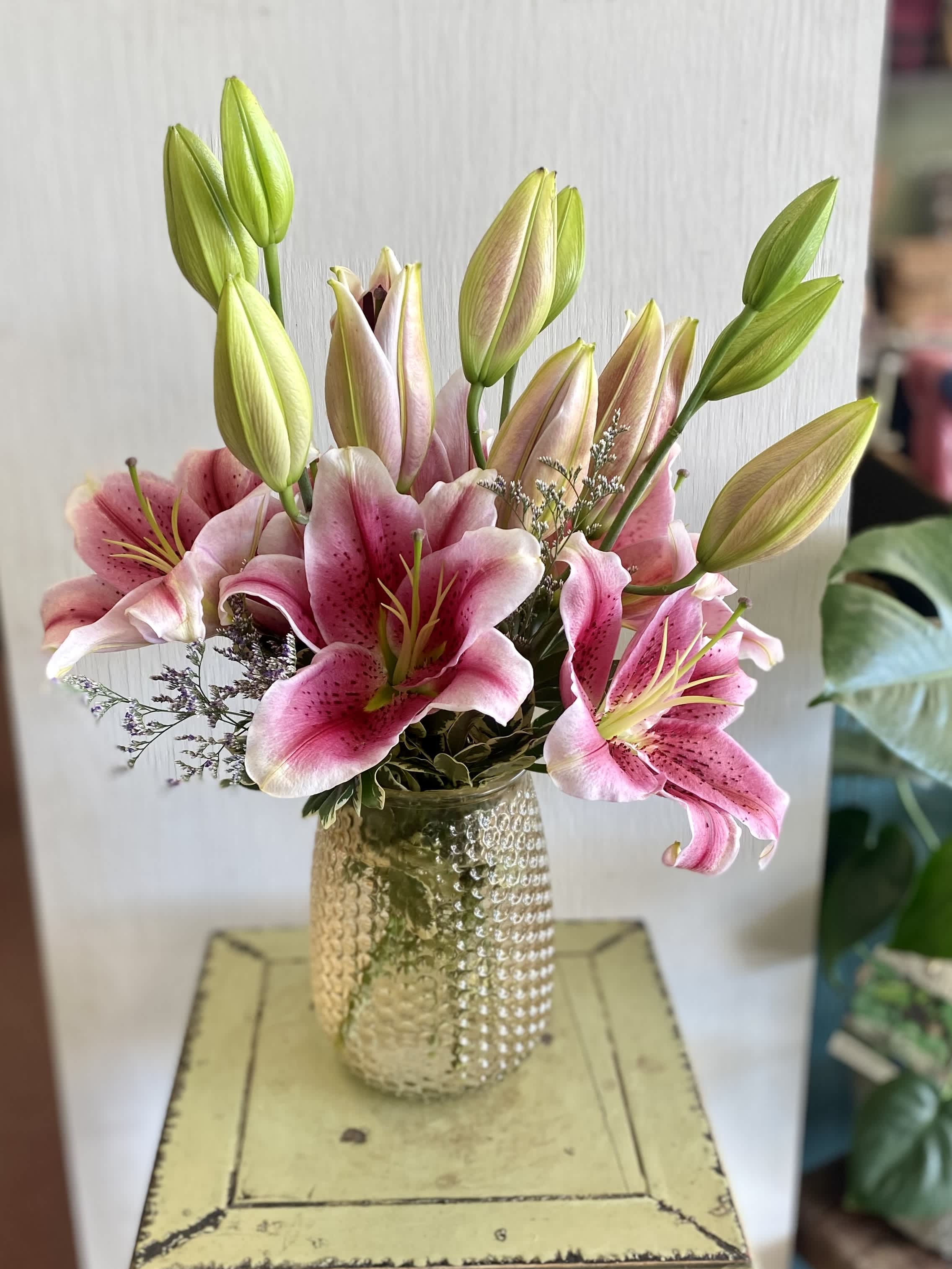 Pink lilies arranged in a textured glass vase
