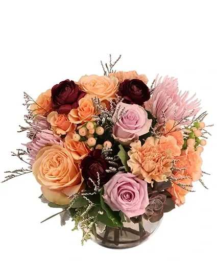 Tender Sunset Floral Arrangement - Soothing and sweet, this arrangement brings out the softness of the setting sun! Settled between lavender roses and burgundy ranunculus, peach roses, carnations, and hypericum will melt anyone's heart. Send Tender Sunset to someone special today!  Includes: Bubble Bowl , Curly Willow (In Vase) , Dusty Miller, Seeded Eucalyptus, Misty Blue, Succulent , Peach Carnations, Peach Hypericum , Burgundy Ranunculus , Peach Roses, Lavender Roses, Lavender Spider Mums, Peach Spray Roses.