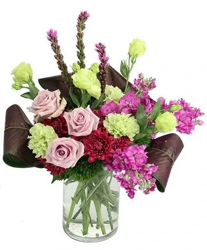 Sensational Sentiment Vase Arrangement - Give them a thrill with this exceptional arrangement! Striking roses, stock, carnations, and more are featured in rich colors of burgundy, purple, and green, making Sensational Sentiment a true masterpiece. Make the most of any occasion with this bewitching bouquet!  Includes: Cylinder Vase , Calathea Leaves, Green Carnations , Green Trick Dianthus , Green Hydrangea , Purple Liatris , Green Lisanthus , Burgundy Cushion Poms, Lavender Roses , Purple Stockvau.