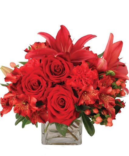 Ruby Rhythm Floral Design - Feel the rhythm of love with this beautiful bouquet of red flowers. Ruby Rhythm is full of beloved blooms like roses, carnations, and lilies. With this stellar lineup, you're sure to set their heart aflutter! Send these pretty flowers to someone you love!  Includes: Clear Cube Vase, Greens: Pittosporum, Salal, Flowers: Red Alstroemeria, Coral Hypericum, Red Roses, Red Carnations, Burgundy Lilies.