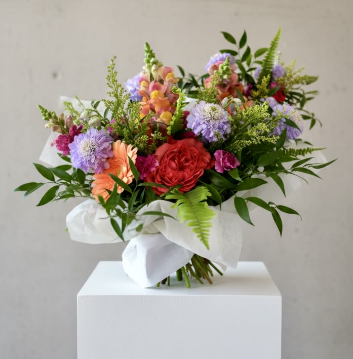 Unconditional Bouquet (Designer’s Choice -bright mix) - Garden-style bouquet is the perfect way to make your mom or the special woman figure in your life feel special. This bouquet is designer’s choice (we pick the freshest blooms that the market has) Hand-tied Bouquet of bright and seasonal flowers. Wrapped in our signature wrap.  Every effort will be made to recreate your chosen design. Please note that from time to time due to product availability and quality we may need to make substitutions. We will make sure to keep the original design in mind when making substitutions.