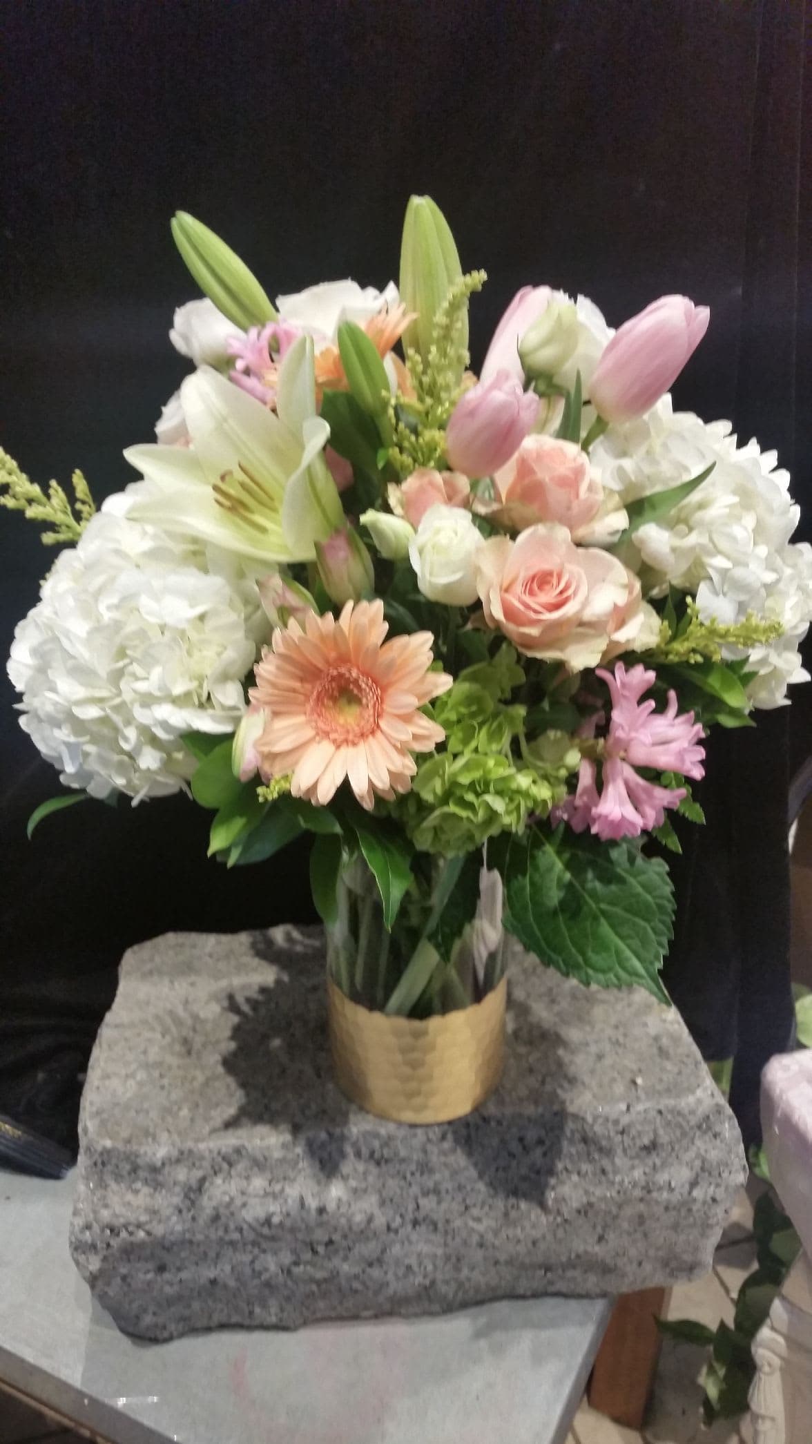 Mixed bouquet in a gold vase with lilies, roses, hydrangeas, and gerbera daisies