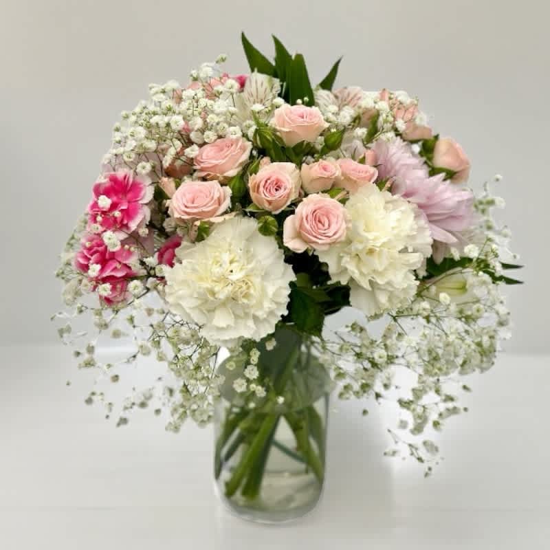 Bouquet of pale pink and white flowers in a clear glass vase