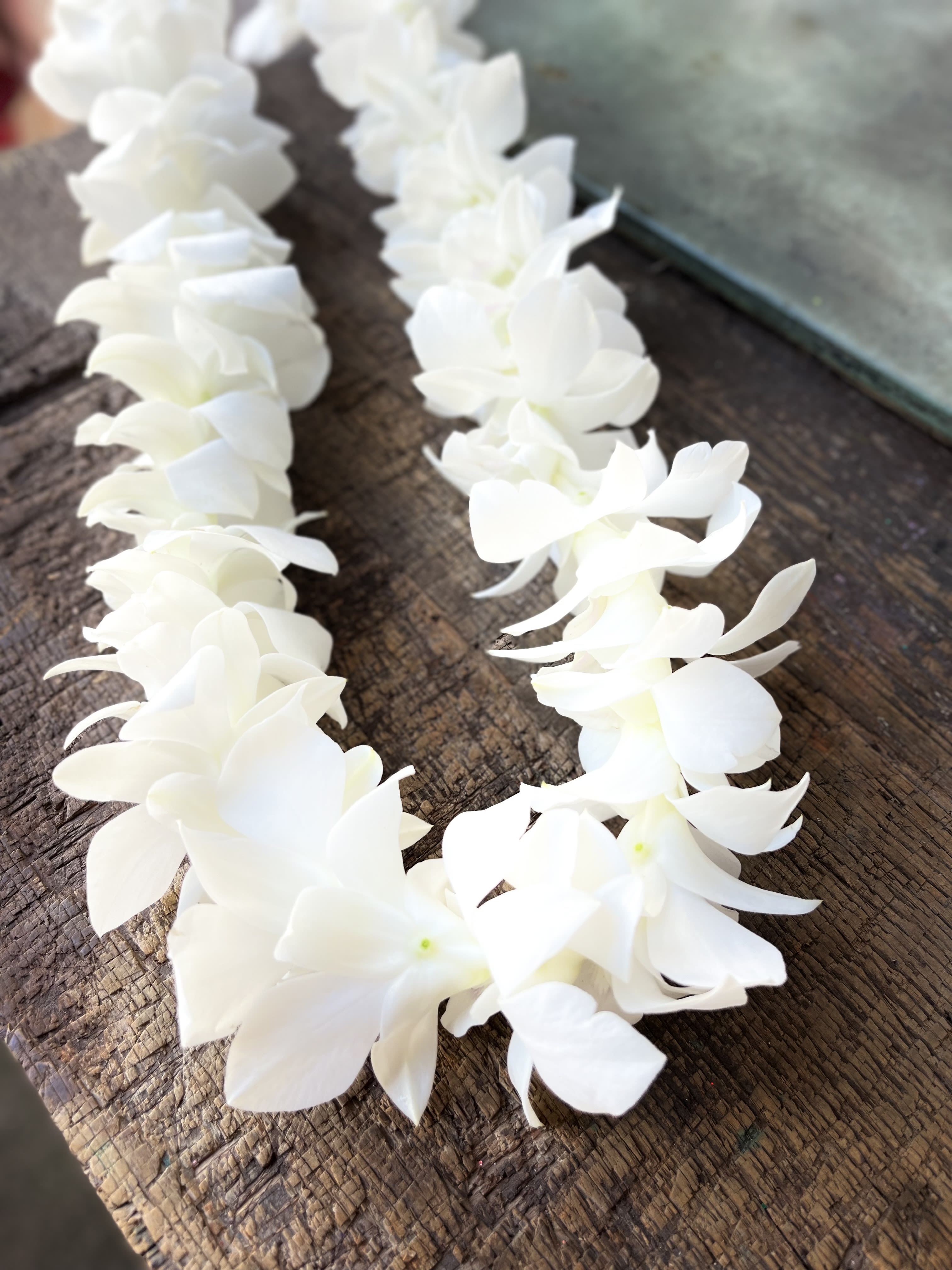 White flower garland laid on a wooden surface