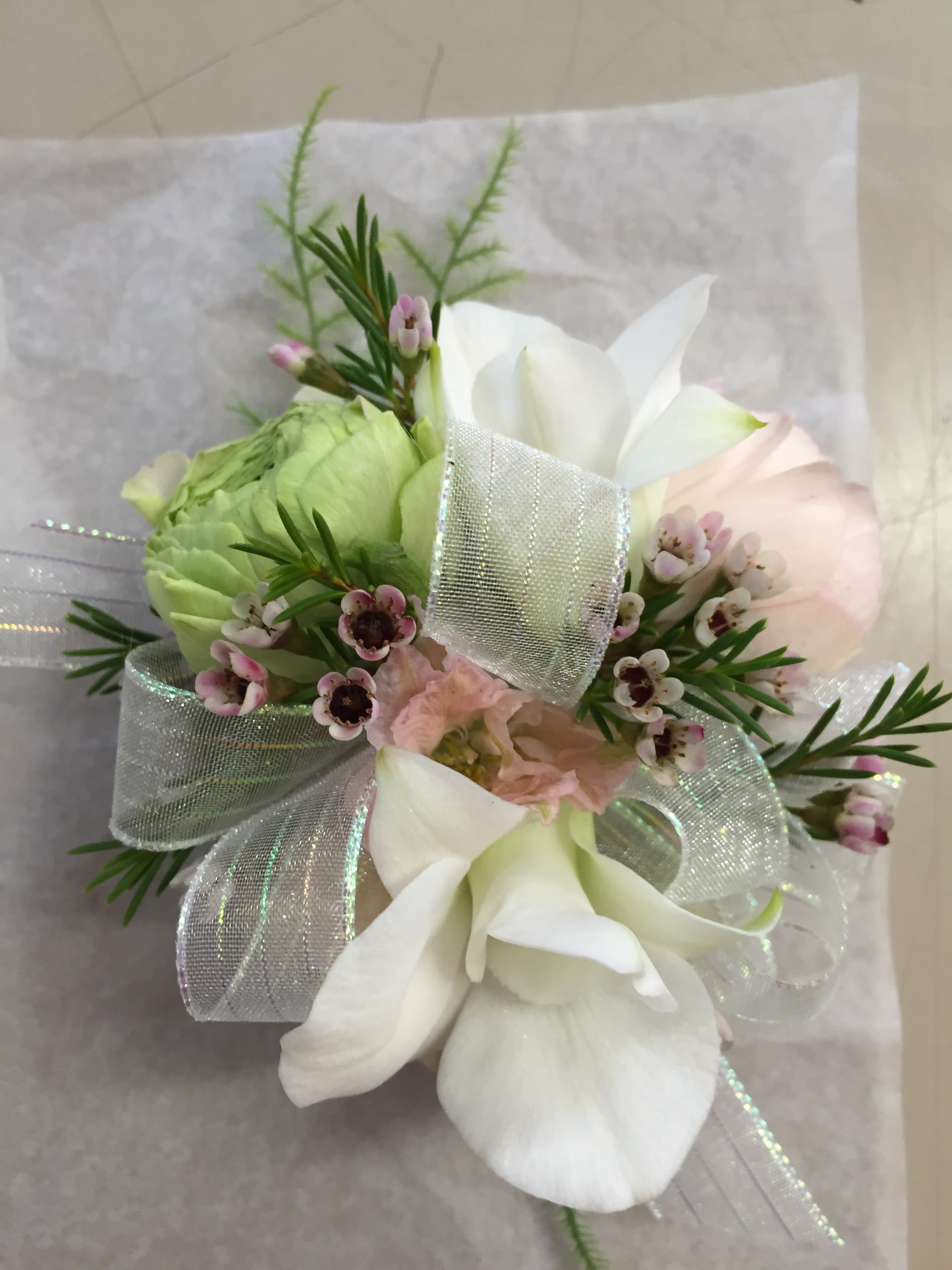 Small bouquet with white calla lilies, pale pink blooms, and a silver ribbon.