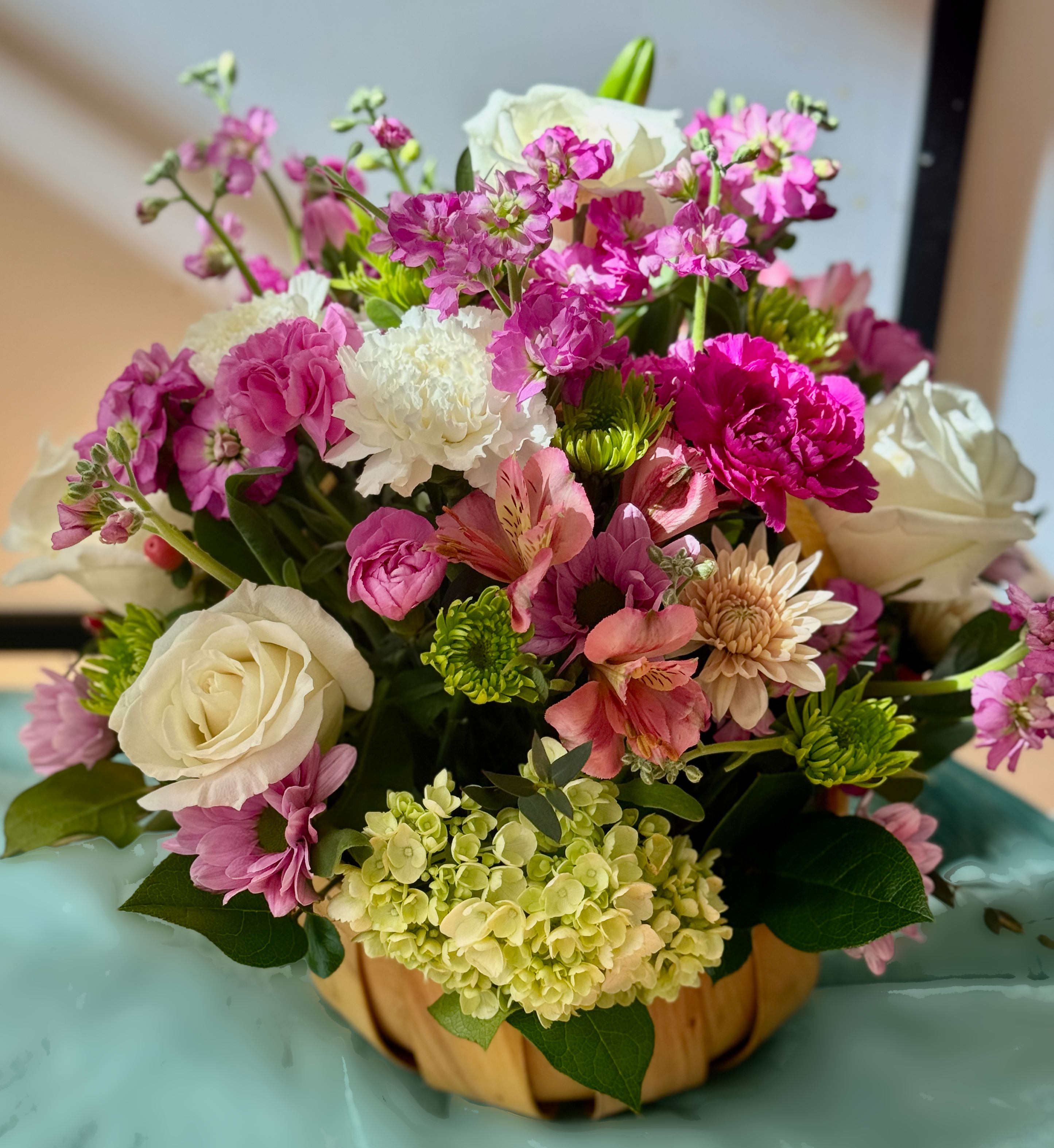 Mixed pink and white flower arrangement in a pumpkin-shaped container