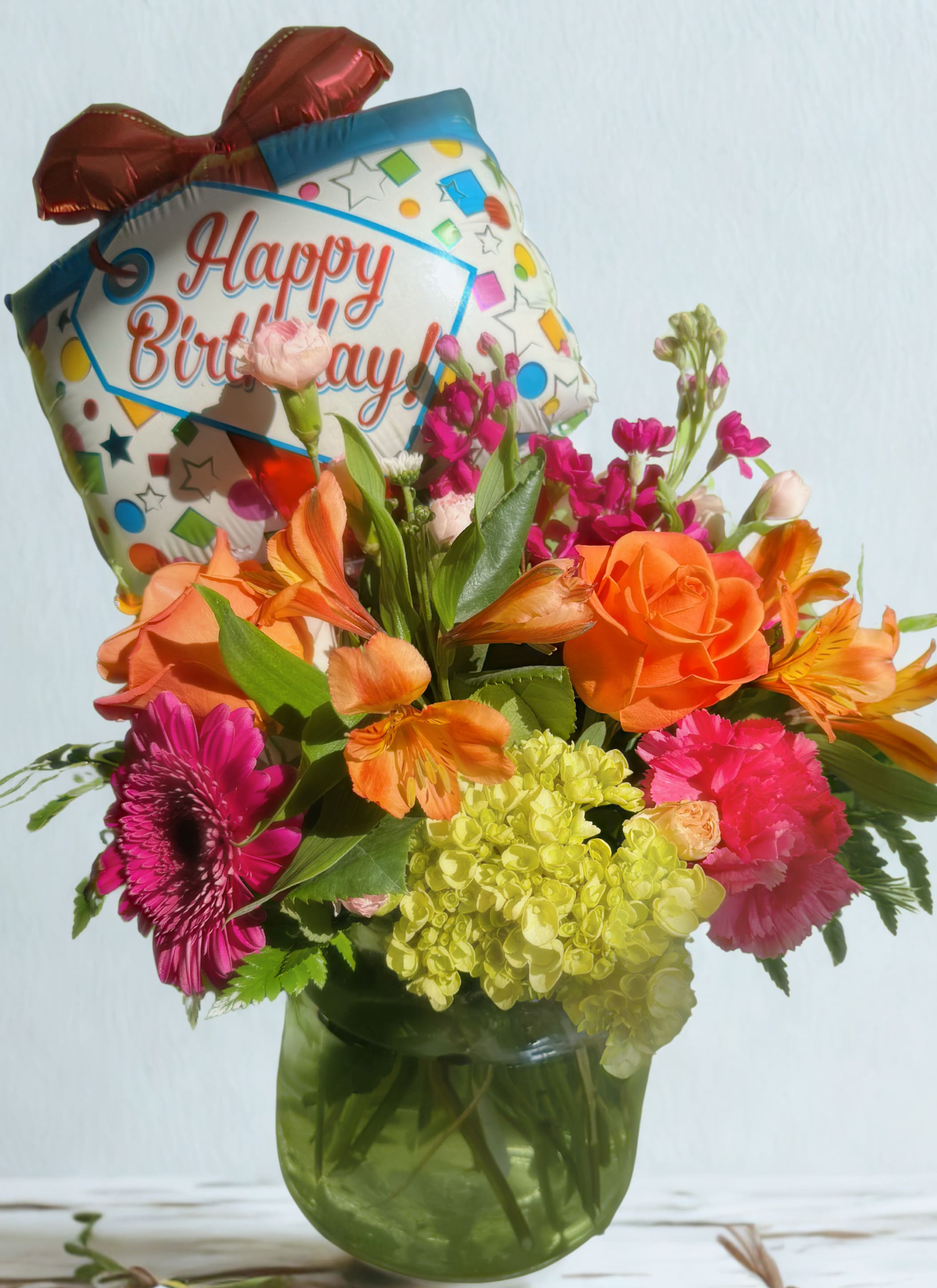 Birthday bouquet with a foil balloon in a glass vase