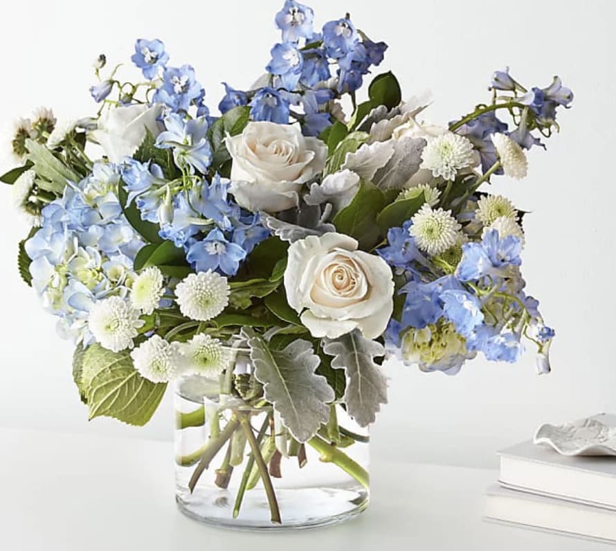 Blue and white flower arrangement in a clear glass vase