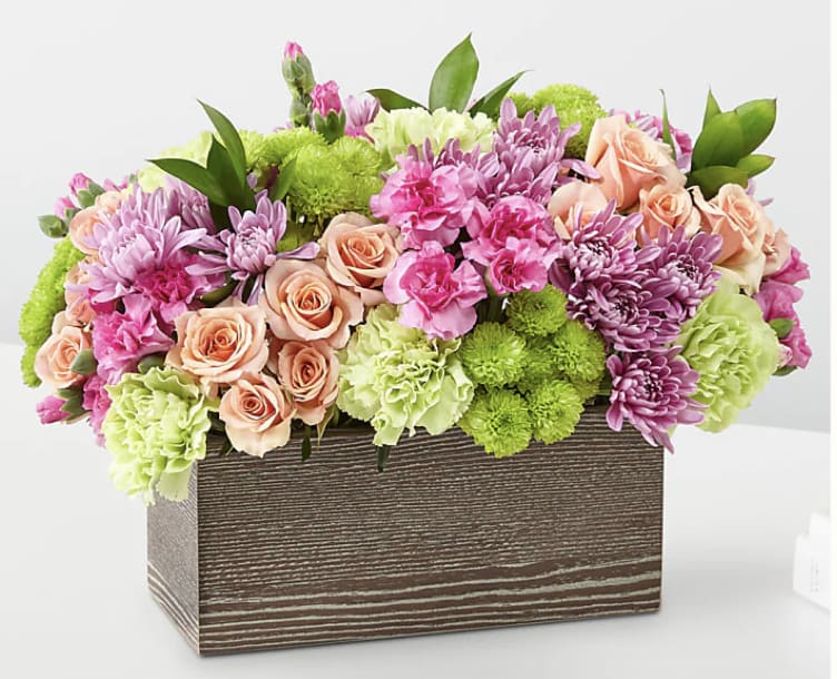 Mixed pink and green flower arrangement in a wooden box