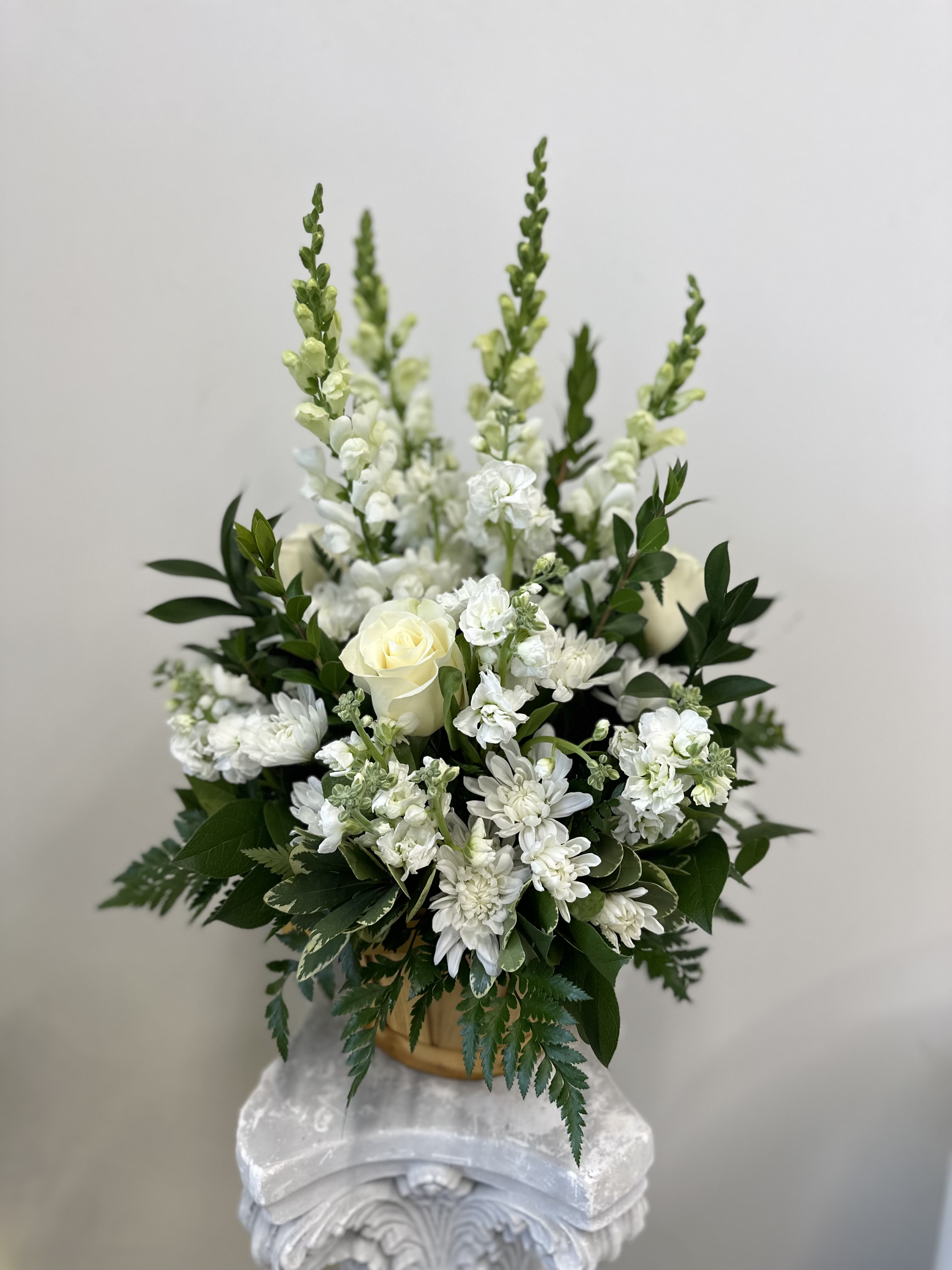 Heartfelt Condolences Arrangement by Westford Florist Art by Veny - The Heartfelt Condolences All around Arrangement by Westford Florist Art by Veny is a beautiful and symbolic way to express your deepest sympathy and condolences to those who are mourning the loss of a loved one. Crafted with care by a local artisan florist, this arrangement is designed on all sides to showcase its stunning white blossoms. Each arrangement is thoughtfully created with individually selected white roses, stock, cushion pompons, and snapdragon, delicately arranged amongst complementary greens. The result is a heartfelt tribute that truly shines and conveys your sincere feelings of support during difficult times. With its warm and welcoming basket base, the Heartfelt Condolences Arrangement is an elegant addition to any wake, funeral service, or graveside ceremony. It can also be sent directly to the home of grieving family or friends as a touching gesture of love and compassion. In times of loss, words may often fail us.  With just a few clicks or a phone call away, you can have this meaningful tribute delivered right to your desired location in no time at all. It's never easy to lose someone we care about deeply, but sending this heartfelt arrangement shows that you are there for them in their time of need. Whether it's for family members or close friends, let the Heartfelt Condolences Arrangement speak volumes on behalf of your sincerest condolences. Place your order today to offer comfort and support during difficult times.