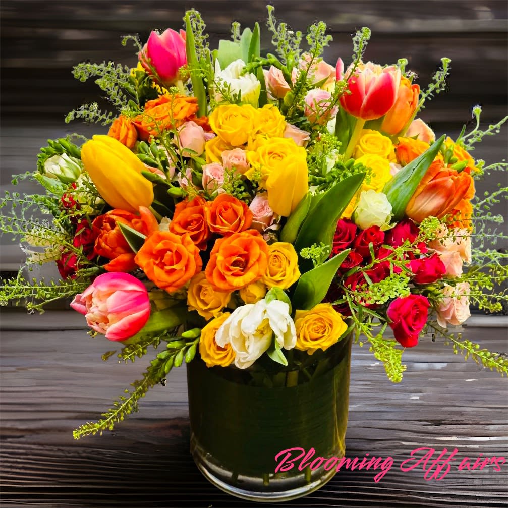 Colorful bouquet of tulips and roses in a glass vase
