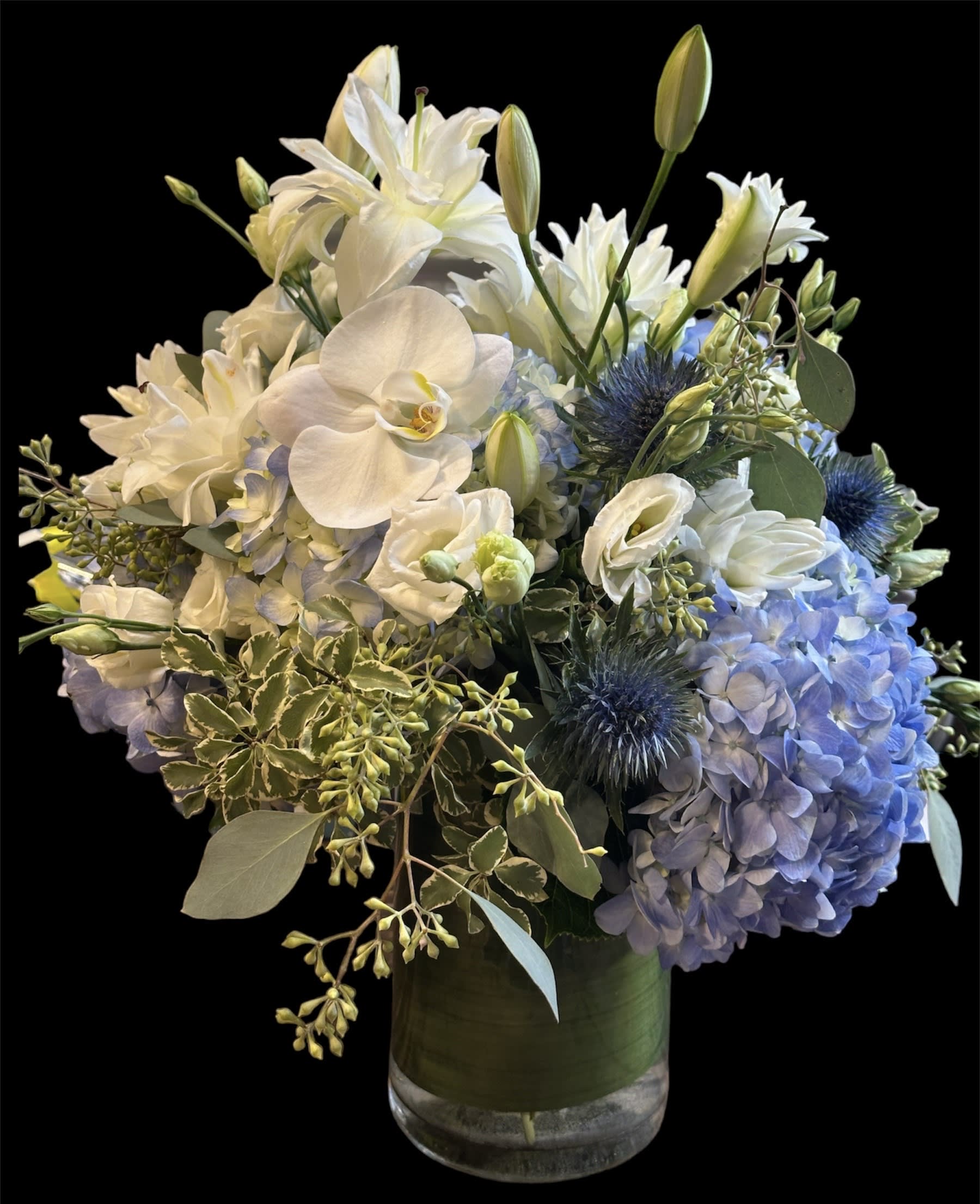 White and blue floral arrangement in a glass vase