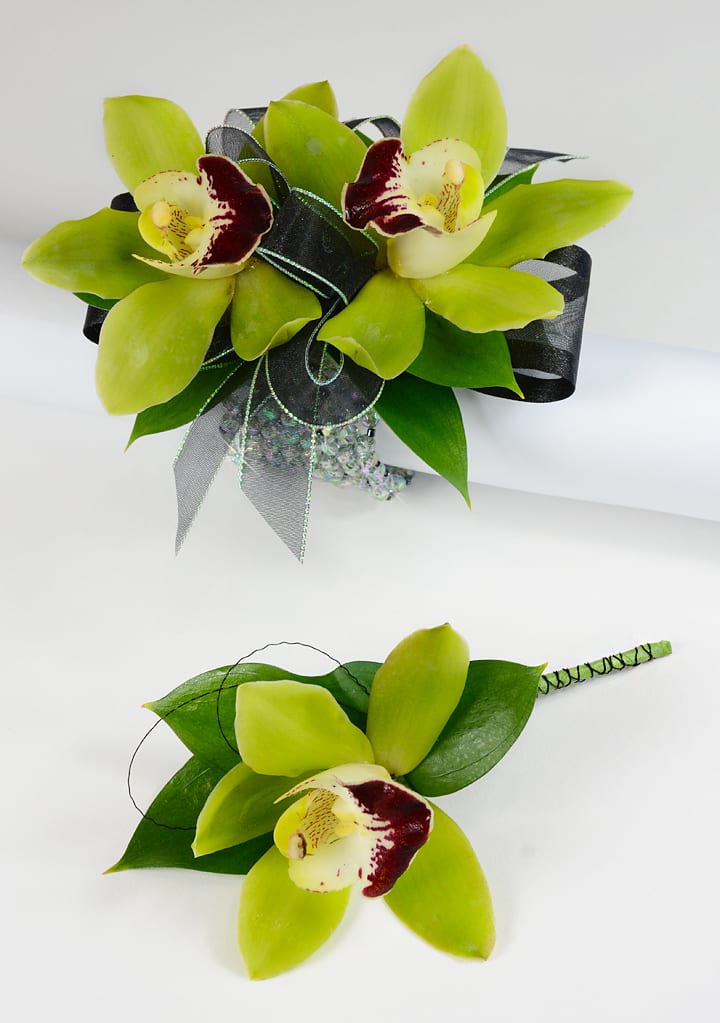 Green orchid bouquet and matching boutonniere with dark ribbon