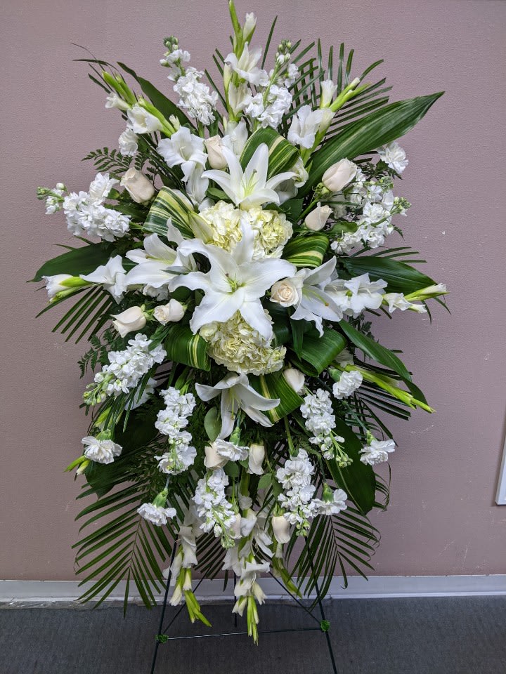 Tall white floral standing spray with lilies and roses
