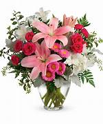 Pink lilies and red roses in a clear glass vase