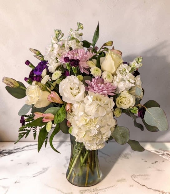 Art &amp; Flowers Exclusive "Pretty Pastels" - This soft and pretty arrangement is just right to show someone you're thinking of them, or just to make them smile. The elegant clear glass vase holds a variety of flowers in shades of white, cream, purples and pinks.   Expertly arranged by our talented designers here at Art &amp; Flowers! 