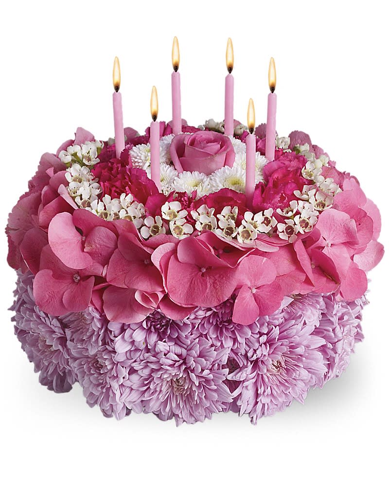 Pink floral cake with lit candles on top