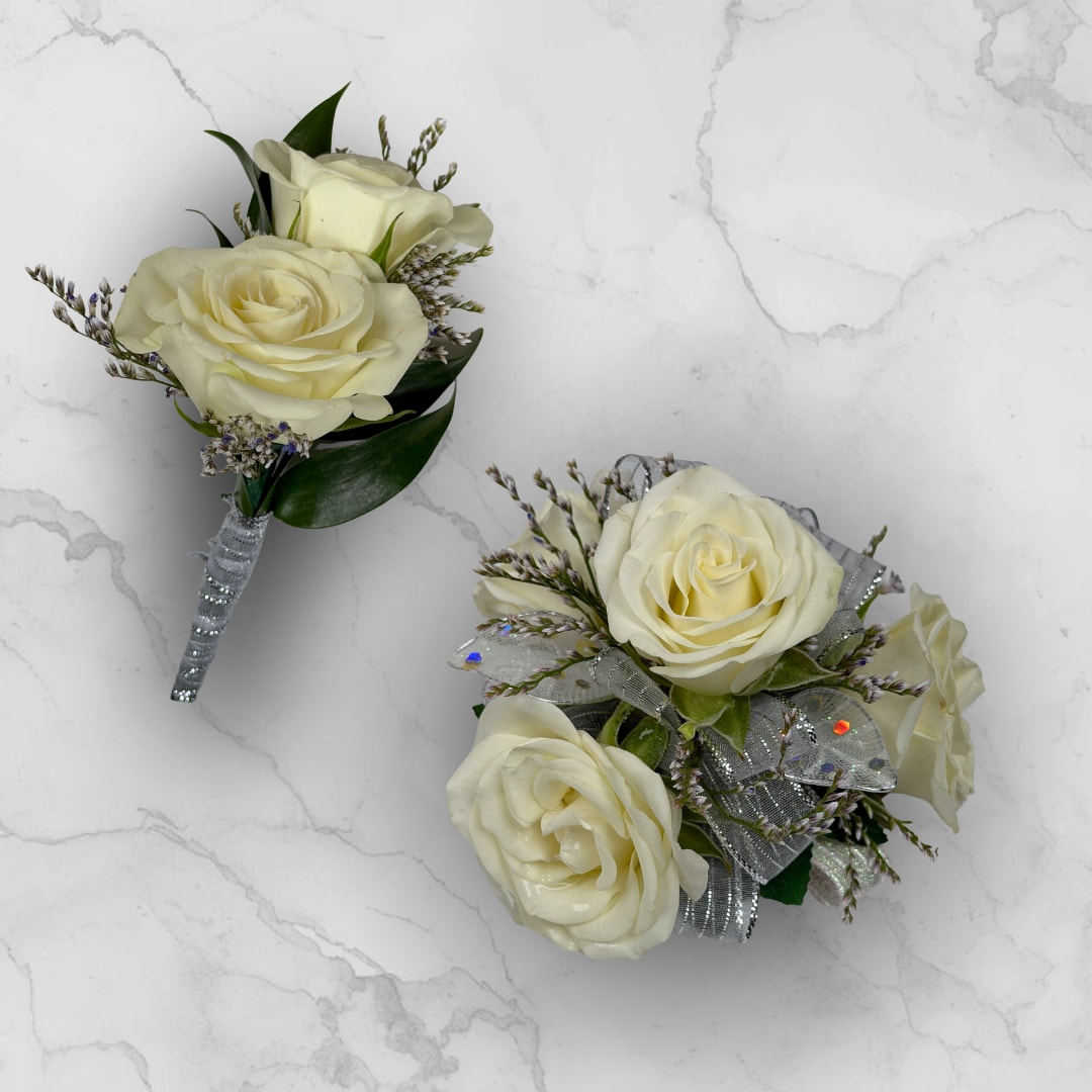 Opal 4 Rose Combo - Make ordering prom flowers a breeze this year with our Opal 4 Rose Combo! This combo comes with our Opal Boutonniere - With Wrap and our Opal 4 Rose Corsage, perfectly matched together to make a stunning, coordinating look.  The Opal 4 Rose Corsage features four cream-white roses gathered into a compact wrist corsage create a quietly elegant accessory for prom, with delicate purple-tipped filler, white sheer sequined ribbon and white faux shimmering leaves for added dazzle and shine. Finished with fabric leaves and a shimmering white lace wristlet, this corsage is a lovely choice to make prom night memorable.  The Opal Boutonniere - With Wrap features two creamy ivory roses, with small limonium filler blooms surrounding the roses, and dark green leaves tucked in beneath to give contrast and depth, so the person wearing it will look polished and truly cared for.
